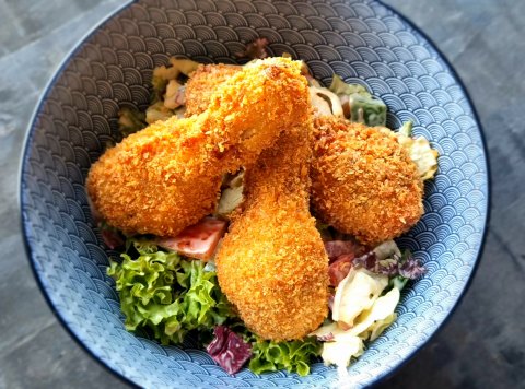 Zeleninový šalát s vyprážanými kuracími stehienkami obalenými v panko strúhanke, sweet chilli majonéza, pizza chlieb (zmes šalátov, uhorka, rajčina, paprika)